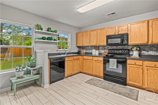 kitchen with black appliances, open shelves, light wood-style flooring, dark countertops, and tasteful backsplash