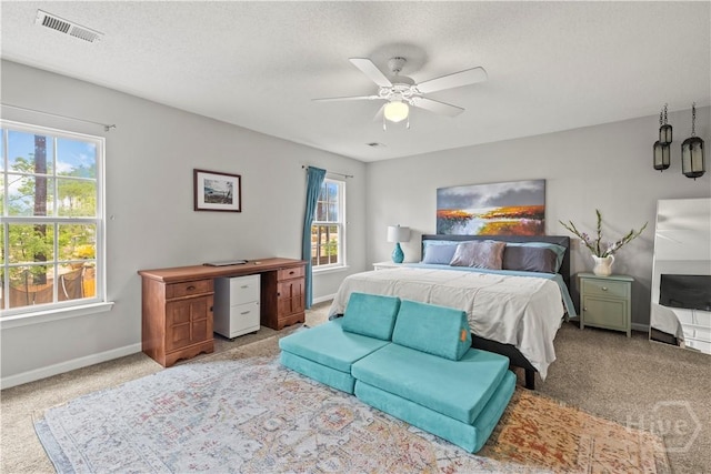 carpeted bedroom with baseboards, a ceiling fan, and a textured ceiling