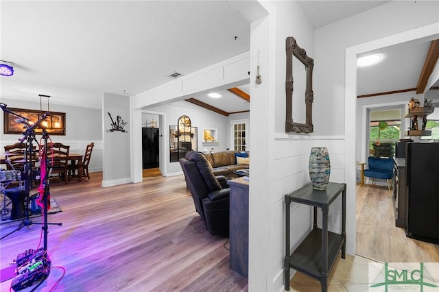 living area featuring light wood-style floors and a wainscoted wall