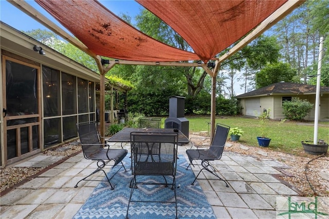 view of patio / terrace featuring outdoor dining area, a sunroom, and an outdoor structure