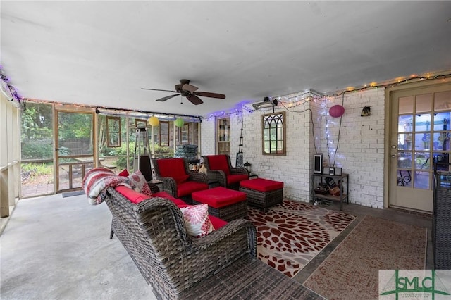living area featuring healthy amount of natural light, a ceiling fan, and concrete floors