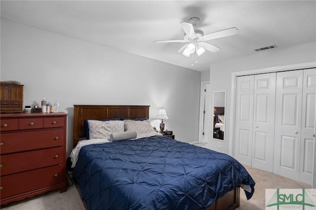bedroom featuring light colored carpet, a closet, and a ceiling fan