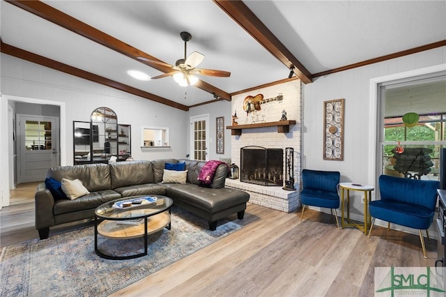 living area with ceiling fan, a brick fireplace, and light wood-style flooring