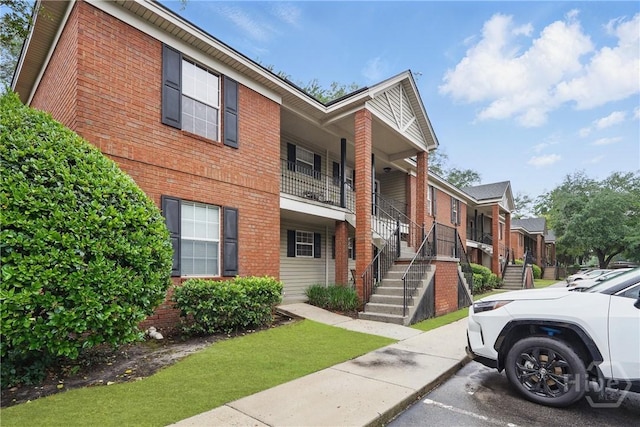 211 Edgewater Rd Unit 22, Savannah, GA 31406 - view of front facade featuring brick siding, covered porch, stairway, and a residential view