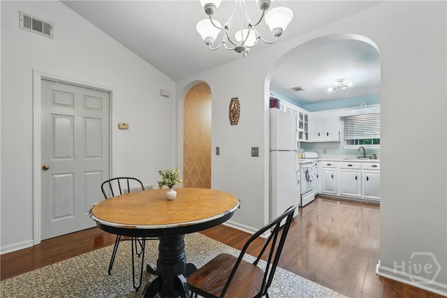 211 Edgewater Rd Unit 22, Savannah, GA 31406 - dining room featuring arched walkways, a chandelier, wood finished floors, vaulted ceiling, and baseboards
