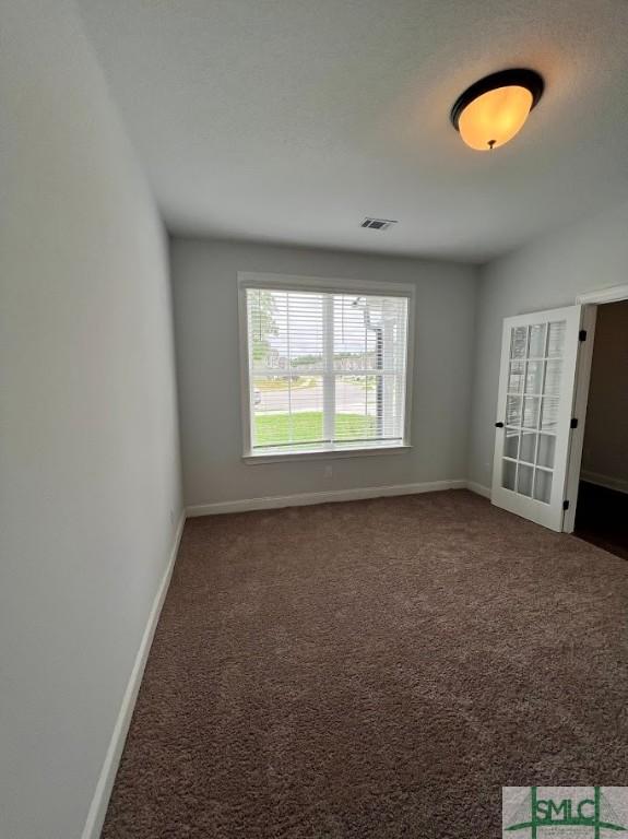 empty room featuring baseboards and carpet floors