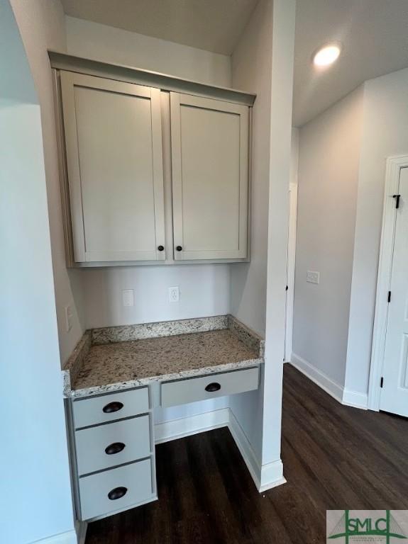unfurnished office with dark wood-style flooring, baseboards, and recessed lighting