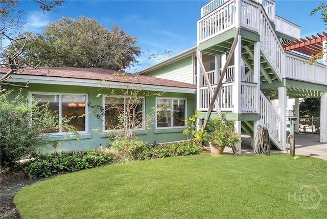 506 Butler Ave, Tybee Island, GA 31328 - rear view of house featuring stairway, a yard, and stucco siding