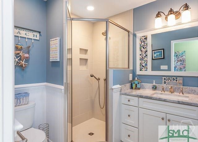 506 Butler Ave, Tybee Island, GA 31328 - full bathroom with a shower stall, toilet, vanity, and a wainscoted wall