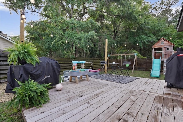 1405 Desert Storm Dr, Hinesville, GA 31313 - wooden deck with a playground, a fenced backyard, and area for grilling