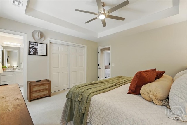 129 Penn Sta, Savannah, GA 31410 - carpeted bedroom featuring a tray ceiling, a closet, ensuite bathroom, and a ceiling fan