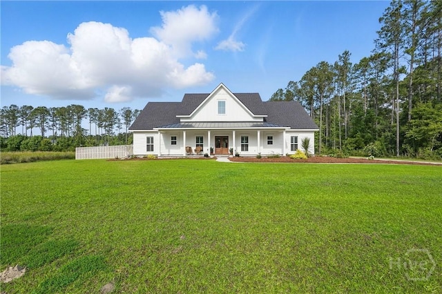 view of front of property featuring a porch, a front yard, and a standing seam roof