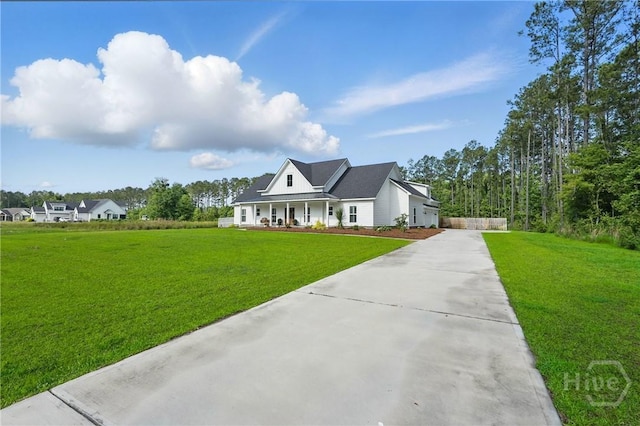 modern farmhouse style home with driveway, a porch, and a front yard