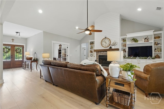 living room with vaulted ceiling, french doors, a ceiling fan, recessed lighting, and a brick fireplace