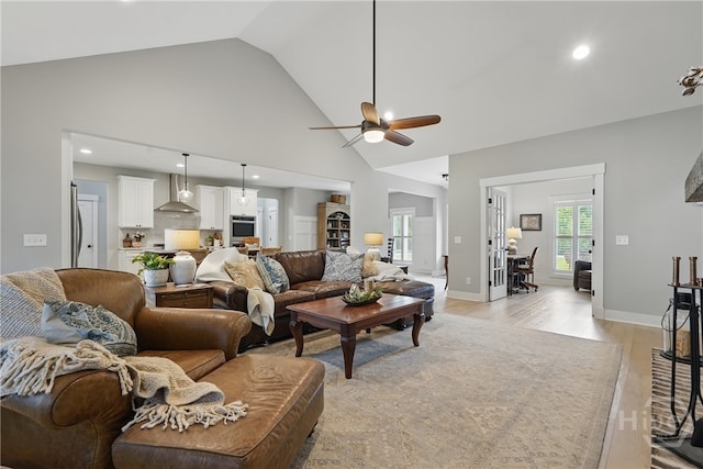 living room featuring ceiling fan, light wood finished floors, recessed lighting, and high vaulted ceiling