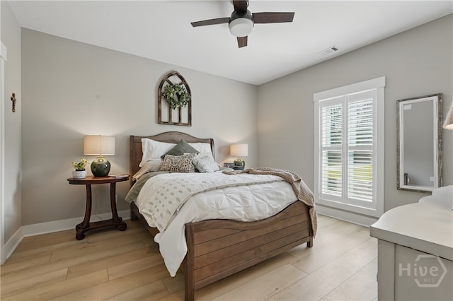 bedroom featuring light wood finished floors, a ceiling fan, and baseboards