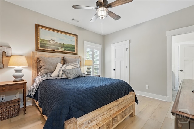 bedroom featuring light wood-style flooring, baseboards, and a ceiling fan