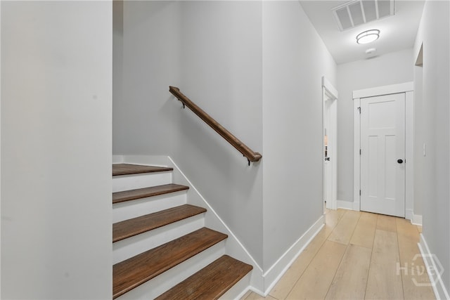 stairway with wood finished floors and baseboards