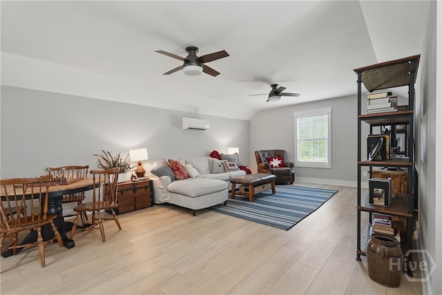 living area featuring ceiling fan, light wood-type flooring, an AC wall unit, baseboards, and vaulted ceiling