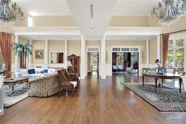 3021 Whitemarsh Way, Savannah, GA 31410 - living room featuring decorative columns, a chandelier, a decorative wall, ornamental molding, and wood finished floors
