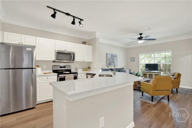 3021 Whitemarsh Way, Savannah, GA 31410 - kitchen with stainless steel appliances, a sink, open floor plan, white cabinetry, and ornamental molding
