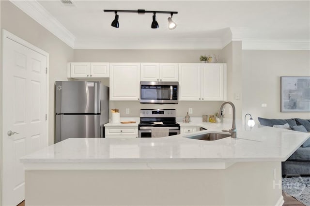 3021 Whitemarsh Way, Savannah, GA 31410 - kitchen featuring stainless steel appliances, a sink, white cabinetry, light stone counters, and rail lighting