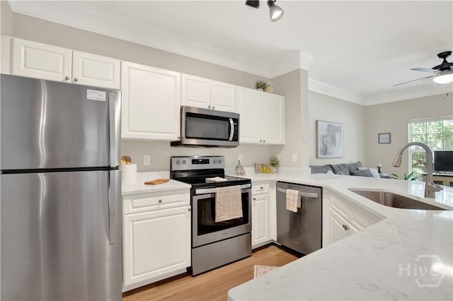 3021 Whitemarsh Way, Savannah, GA 31410 - kitchen featuring stainless steel appliances, a sink, light wood-style flooring, open floor plan, and white cabinets