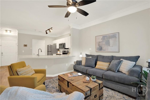 3021 Whitemarsh Way, Savannah, GA 31410 - living room featuring light wood-style flooring, ceiling fan, crown molding, rail lighting, and baseboards