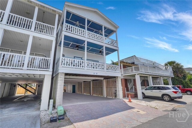 5 17th St, Tybee Island, GA 31328 - view of front of property with a balcony, stairway, a ceiling fan, and covered parking