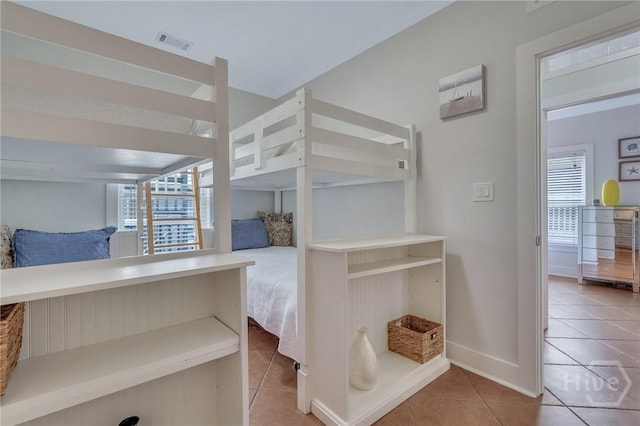 5 17th St, Tybee Island, GA 31328 - unfurnished bedroom featuring multiple windows, tile patterned flooring, and baseboards