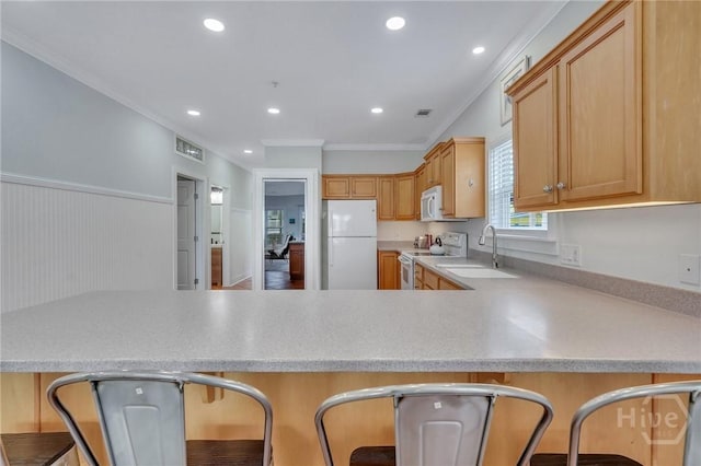 5 17th St, Tybee Island, GA 31328 - kitchen with white appliances, a sink, light countertops, ornamental molding, and a peninsula