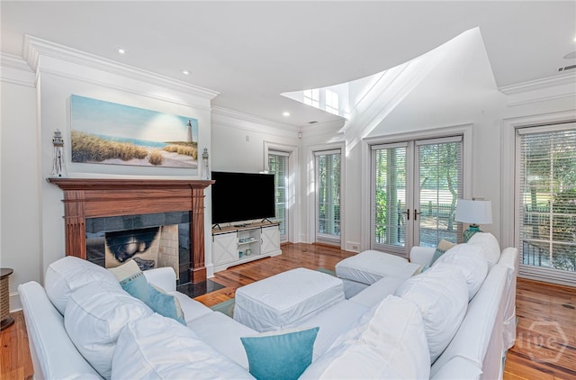 living room featuring crown molding, a fireplace, wood finished floors, and recessed lighting