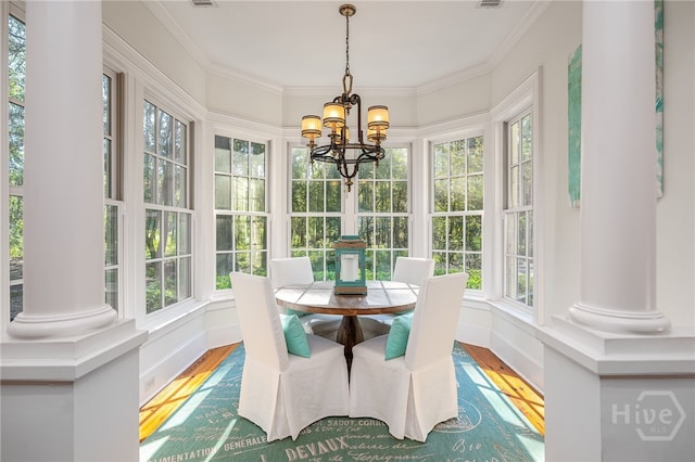 sunroom / solarium with wood finished floors, healthy amount of natural light, and crown molding