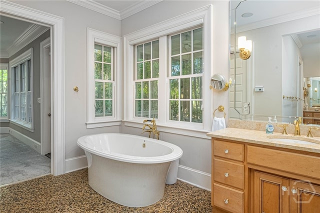 full bathroom featuring baseboards, a freestanding tub, vanity, and crown molding
