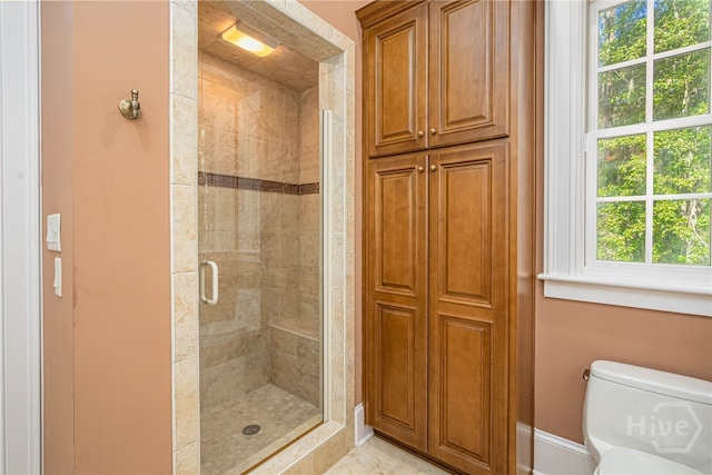 bathroom with a shower stall, plenty of natural light, and baseboards