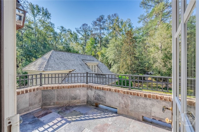 view of patio / terrace featuring a balcony and view of wooded area