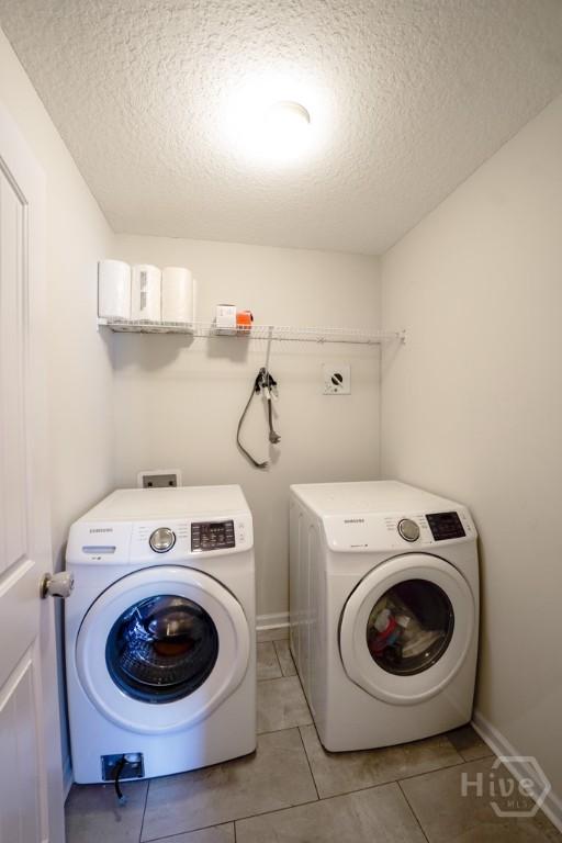 24 Daylily Ct, Hinesville, GA 31313 - washroom featuring a textured ceiling, separate washer and dryer, light tile patterned floors, and baseboards