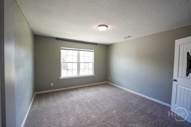 24 Daylily Ct, Hinesville, GA 31313 - empty room featuring carpet floors, a textured ceiling, and baseboards