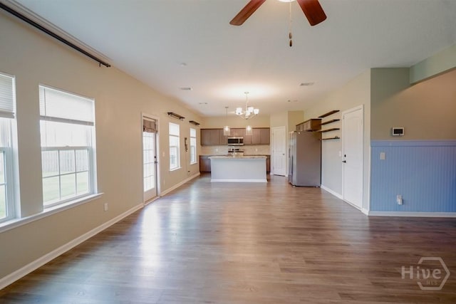 24 Daylily Ct, Hinesville, GA 31313 - unfurnished living room with a chandelier, dark wood finished floors, ceiling fan, a wainscoted wall, and baseboards
