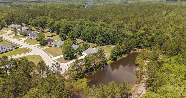 aerial view of property's location featuring a heavily wooded area and a nearby body of water