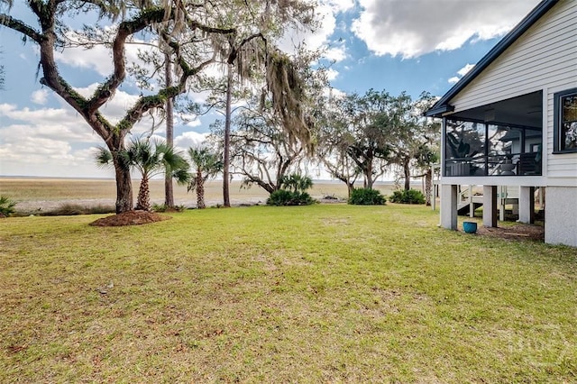 view of grassy yard with a sunroom