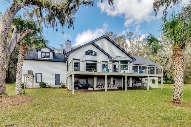 back of property with a deck, a yard, a chimney, a shingled roof, and stairway