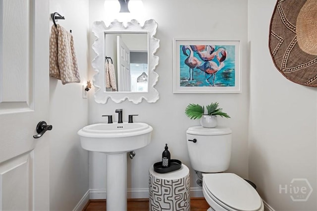 half bath featuring toilet and baseboards