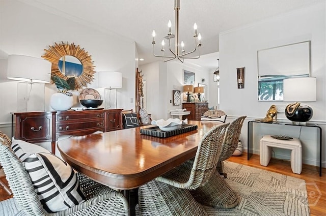 dining area featuring a chandelier, wood finished floors, and baseboards