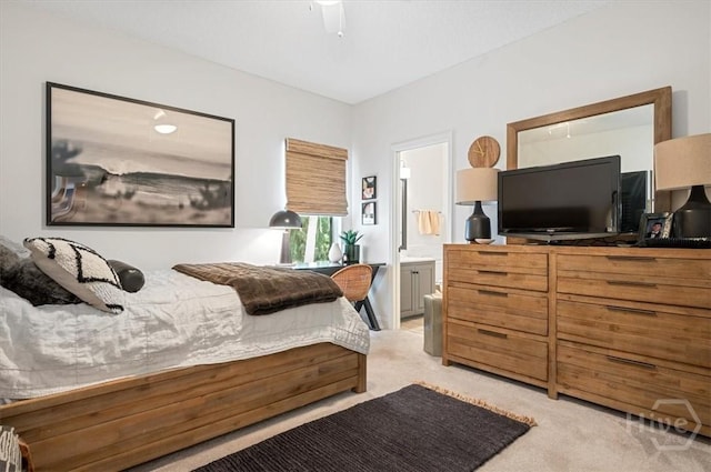 bedroom with light colored carpet, ensuite bath, and ceiling fan