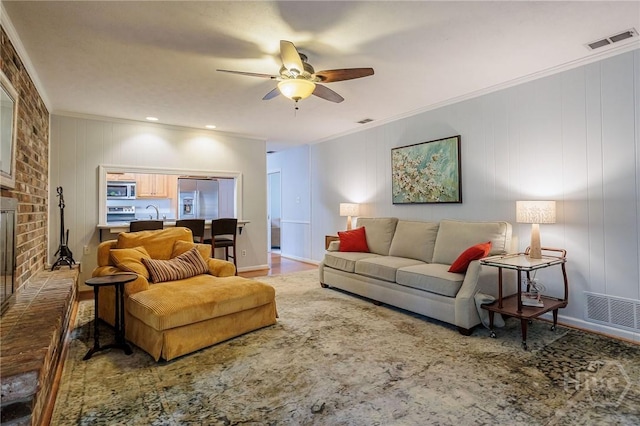 2 S Millward Rd, Savannah, GA 31410 - living room featuring ceiling fan, ornamental molding, a fireplace, and wood finished floors