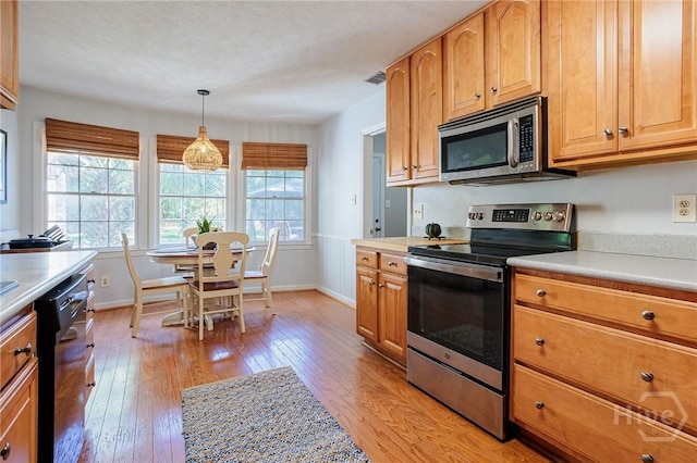 2 S Millward Rd, Savannah, GA 31410 - kitchen with stainless steel appliances, light countertops, baseboards, light wood finished floors, and pendant lighting