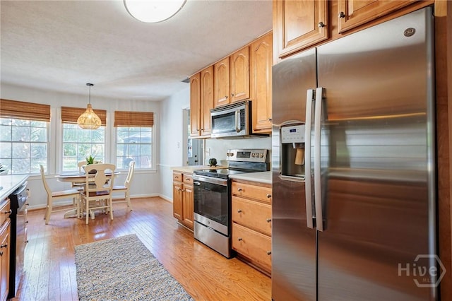 2 S Millward Rd, Savannah, GA 31410 - kitchen featuring stainless steel appliances, light countertops, baseboards, light wood finished floors, and hanging light fixtures