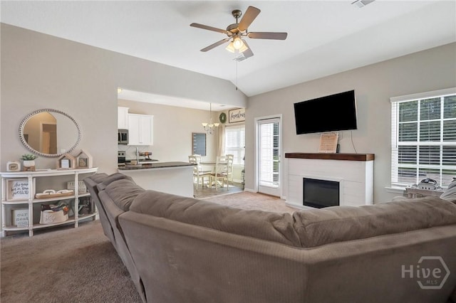 374 Bobwhite Trl NE, Ludowici, GA 31316 - living area featuring light carpet, lofted ceiling, a ceiling fan, a chandelier, and a fireplace