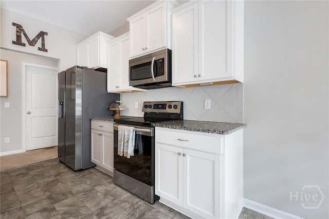 374 Bobwhite Trl NE, Ludowici, GA 31316 - kitchen featuring stainless steel appliances, tasteful backsplash, dark stone countertops, and white cabinetry